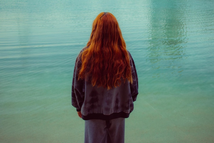 Photo vue arrière d'une femme debout contre la mer