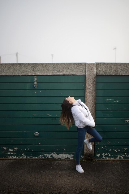 Photo vue arrière d'une femme debout contre le mur