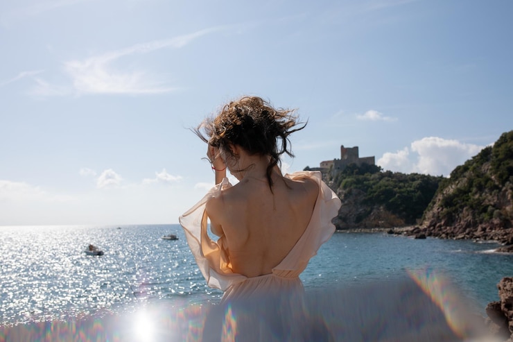 Photo vue arrière d'une femme debout dans la mer contre le ciel