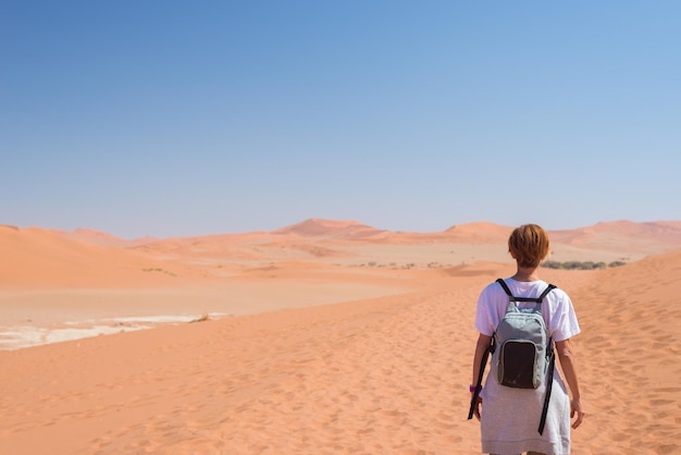 Vue arrière d'une femme debout sur une dune de sable