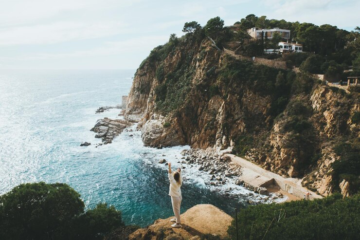 Photo vue arrière femme debout sur une falaise contre la mer