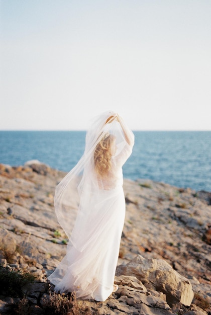 Photo vue arrière d'une femme debout sur la plage contre le ciel