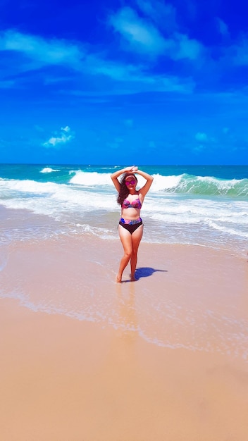 Photo vue arrière d'une femme debout sur la plage