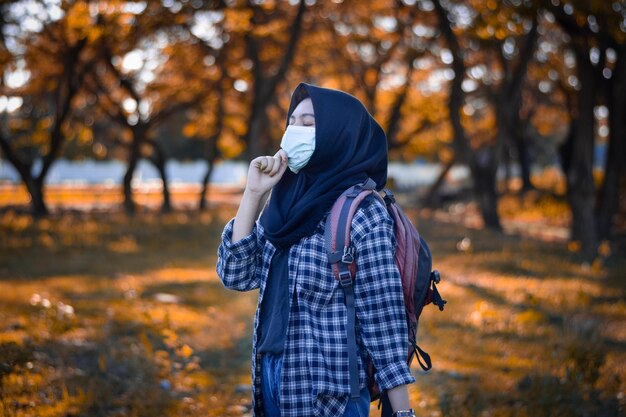 Photo vue arrière d'une femme debout près d'un arbre en automne