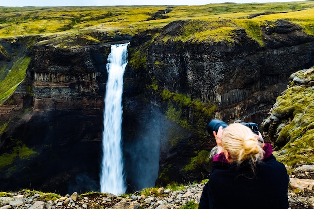 Photo vue arrière d'une femme debout près d'une cascade