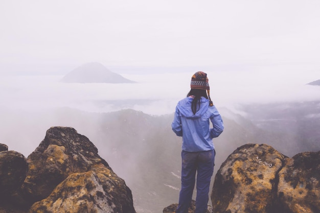 Vue arrière d'une femme debout sur un rocher contre le ciel