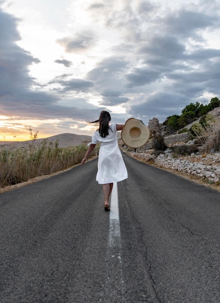 Vue arrière d'une femme debout sur la route contre le ciel