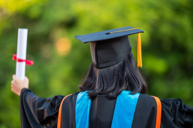 Vue arrière d'une femme diplômée avec un diplôme universitaire