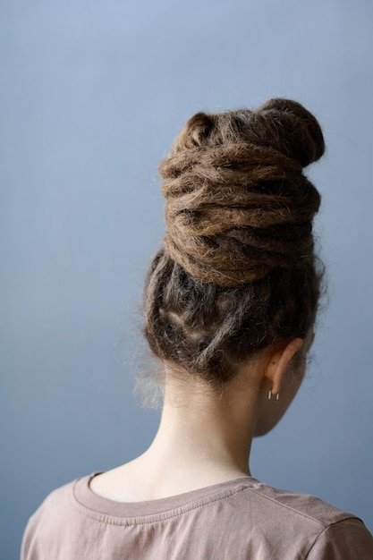 Photo vue arrière d'une femme avec des dreadlocks dans un chou tourné vers le gris