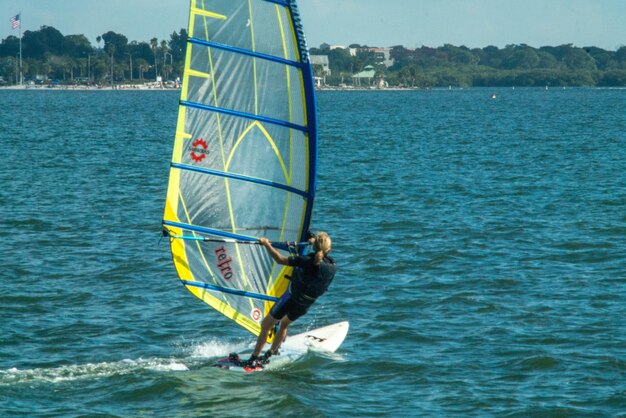 Photo vue arrière d'une femme faisant du windsurf en mer