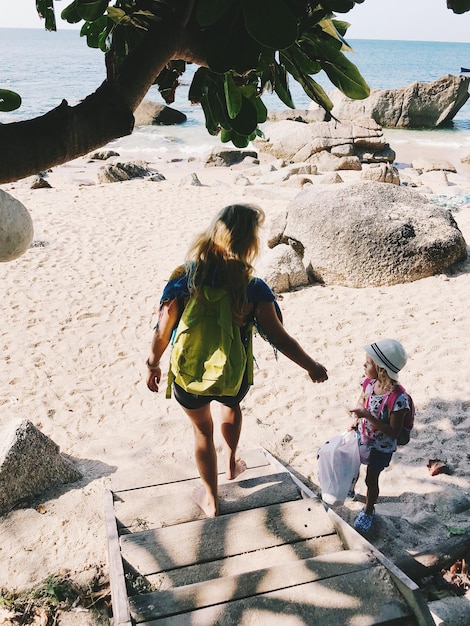 Photo vue arrière d'une femme et d'une fille sur la plage