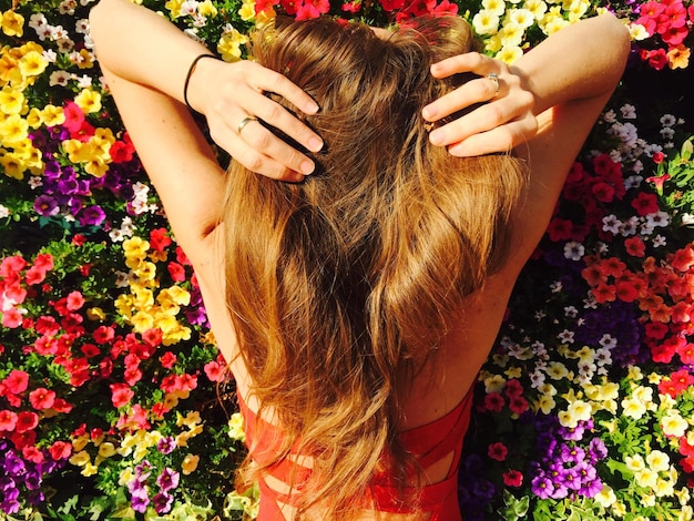 Vue arrière d'une femme sur des fleurs.