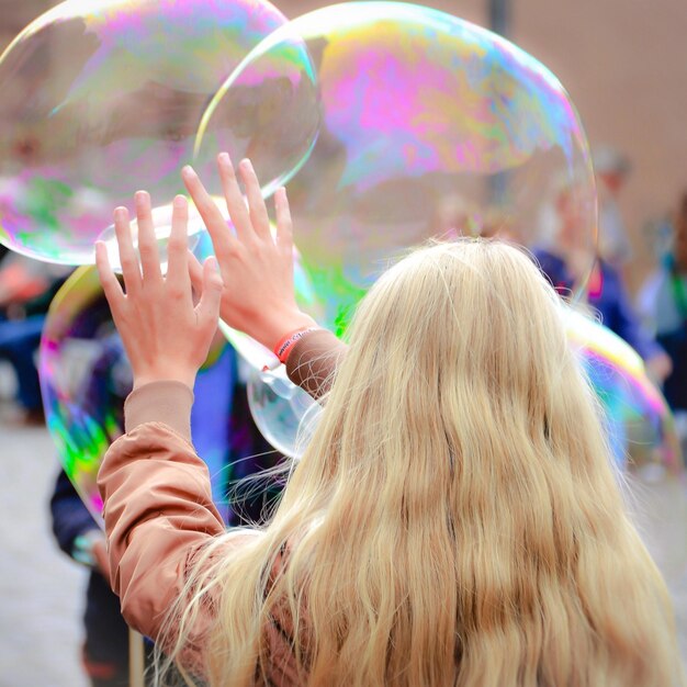 Vue arrière d'une femme jouant avec des bulles