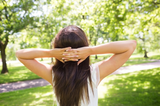 Vue arrière de la femme avec les mains derrière la tête