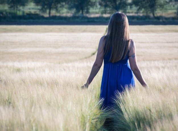 Photo vue arrière d'une femme marchant sur le champ