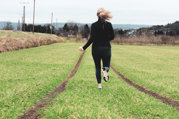 Photo vue arrière d'une femme marchant sur le champ