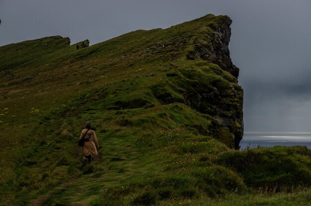 Vue arrière d'une femme marchant sur une route de montagne