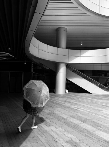 Photo vue arrière d'une femme marchant sur le sol en bois dans un bâtiment