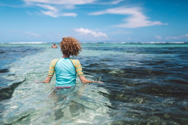 Photo vue arrière d'une femme en mer contre le ciel