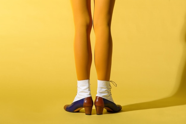 Vue arrière d'une femme mince avec des jambes maigres portant un collant ou un collant jaune moutarde