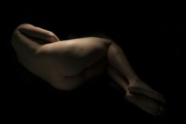 Vue arrière d'une femme nue sur un fond sombre