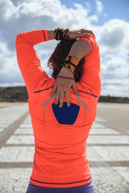 Photo vue arrière d'une femme avec un parapluie debout sur la plage