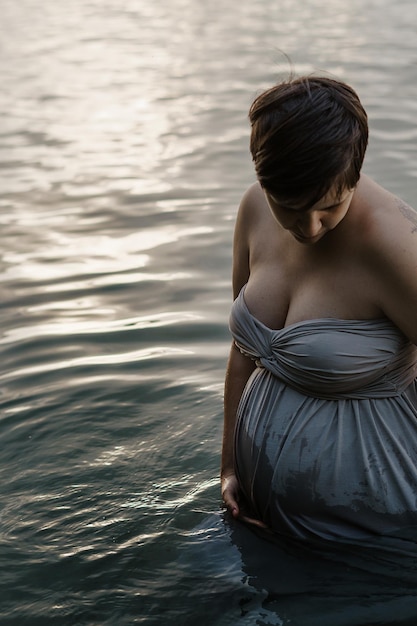 Photo vue arrière d'une femme avec un parapluie en mer