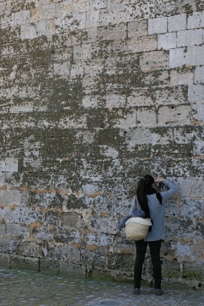 Photo vue arrière d'une femme photographiant contre le mur