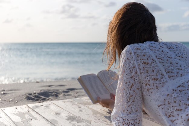 Photo vue arrière d'une femme sur la plage contre le ciel