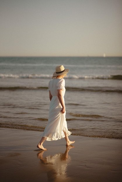 Vue arrière d'une femme sur la plage contre le ciel