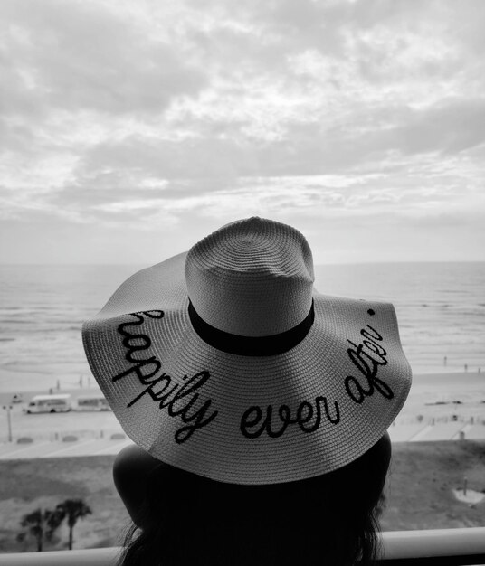 Photo vue arrière d'une femme portant un chapeau sur la plage