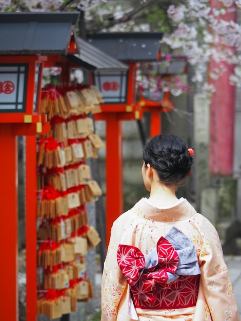 Photo vue arrière d'une femme portant un kimono à l'extérieur du temple