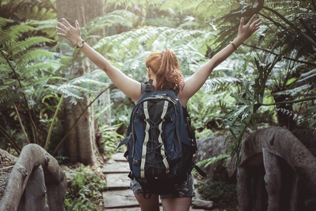 Photo vue arrière d'une femme qui marche dans la forêt