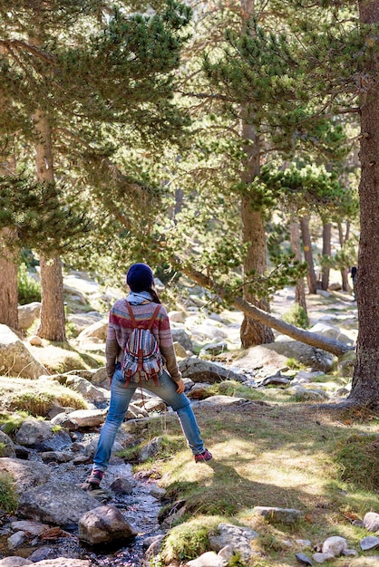 Vue arrière d'une femme qui marche dans la forêt