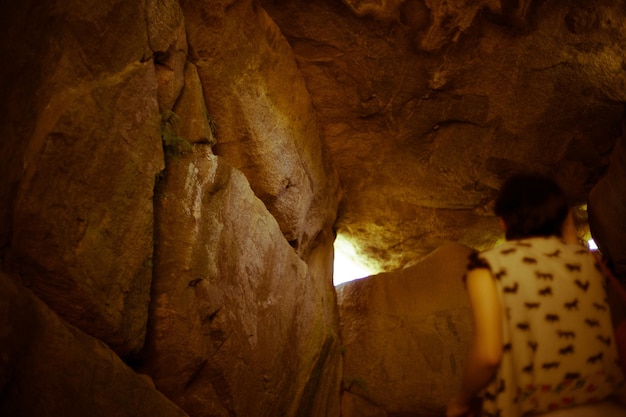 Photo vue arrière d'une femme qui marche dans une grotte