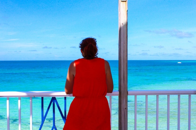 Photo vue arrière d'une femme regardant la mer contre le ciel