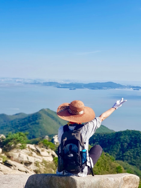 Vue arrière d'une femme regardant les montagnes contre le ciel