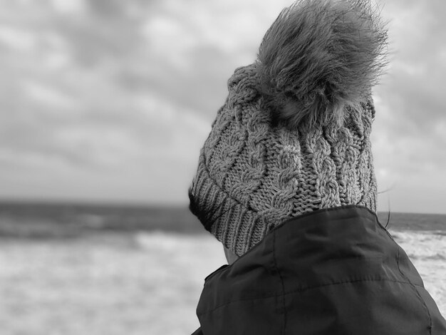 Photo vue arrière d'une femme regardant le rivage contre le ciel