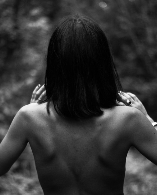 Photo vue arrière d'une femme sans chemise debout à l'extérieur.