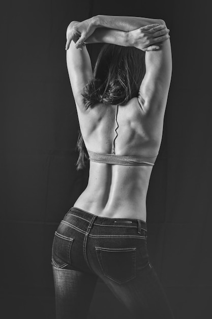Photo vue arrière d'une femme séduisante debout sur un fond noir