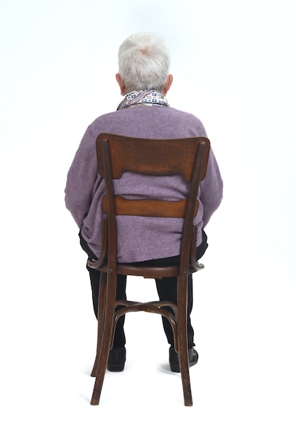 Vue arrière d'une femme senir assise sur une chaise sur fond blanc