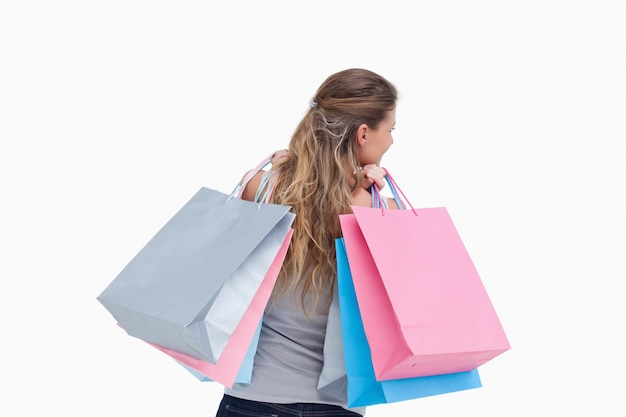 Vue arrière d&#39;une femme tenant des sacs à provisions