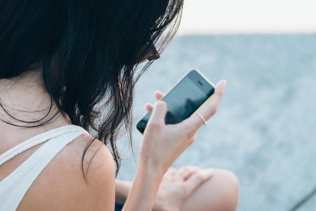 Vue arrière d'une femme utilisant un smartphone