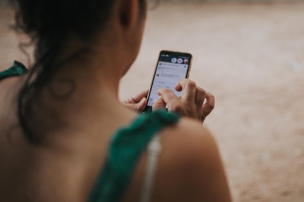 Vue arrière d'une femme utilisant un téléphone