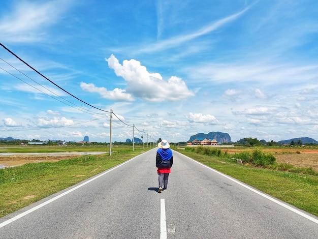 Vue arrière de femmes marchant sur la route contre le ciel