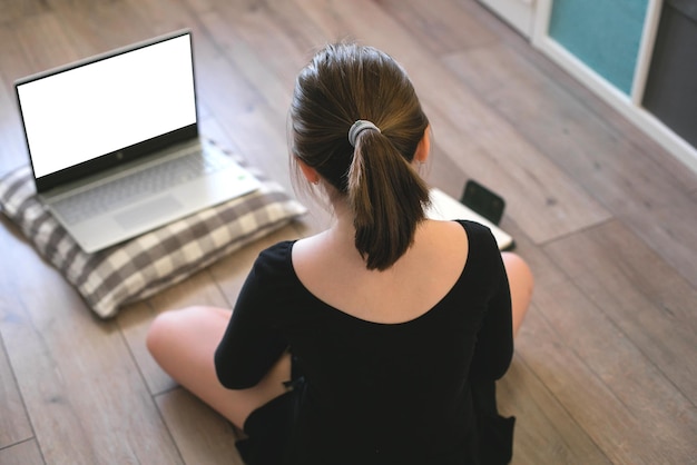 Photo vue arrière d'une fille assise sur le sol à la maison