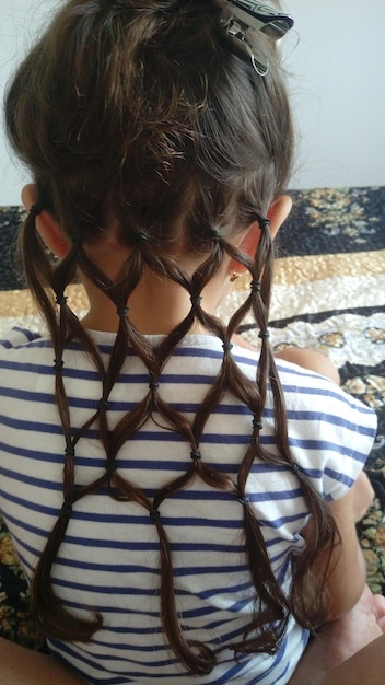 Vue arrière d'une fille aux cheveux tressés à la maison