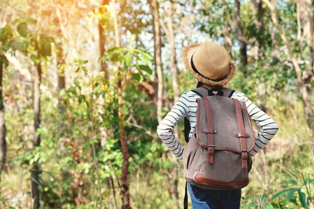 Vue arrière d'une fille debout contre des arbres sur le champ