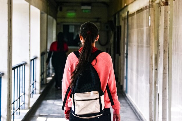 Photo vue arrière d'une fille qui marche dans le couloir