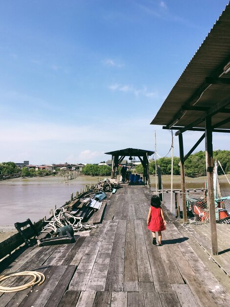 Vue arrière des filles sur le pont contre le ciel